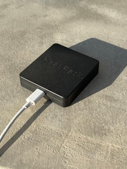 Black metal device with cable on a concrete surface
