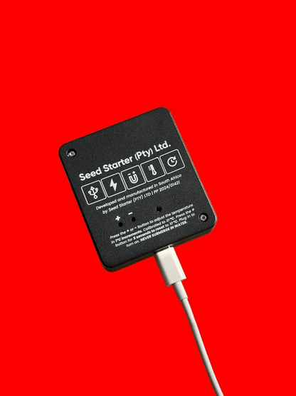 Black electronic device with USB cable on a red background